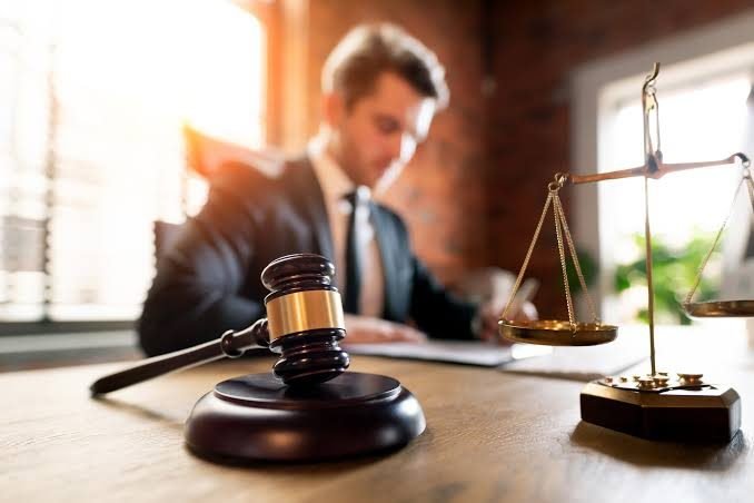 Advogado analisando processo com balança da justiça — assistência técnica em engenharia para escritórios de advocacia