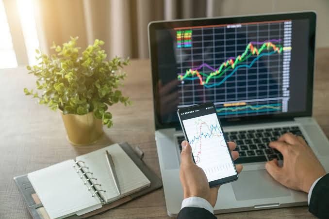Investidor analisando gráficos de mercado — avaliação técnica de imóveis para imobiliárias e investidores